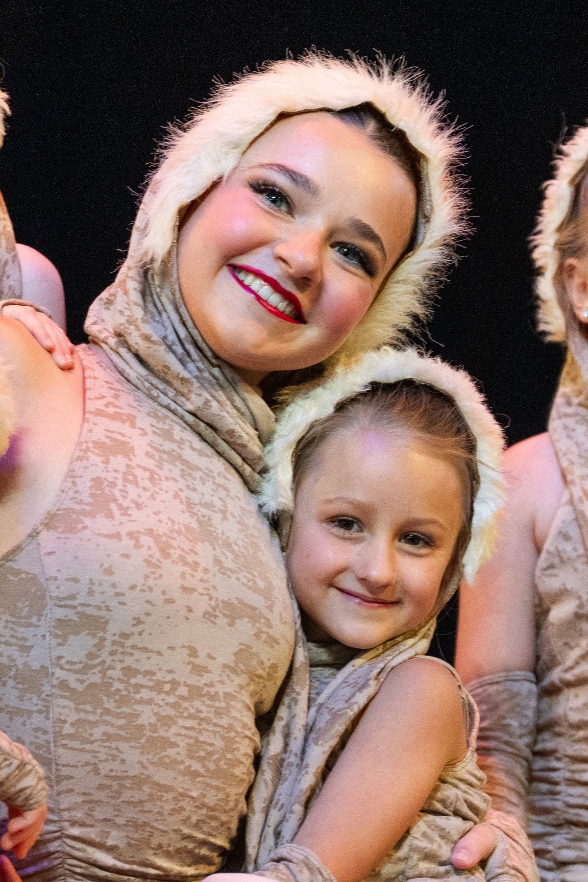 Two CRYB performers sharing a joyful moment in costume